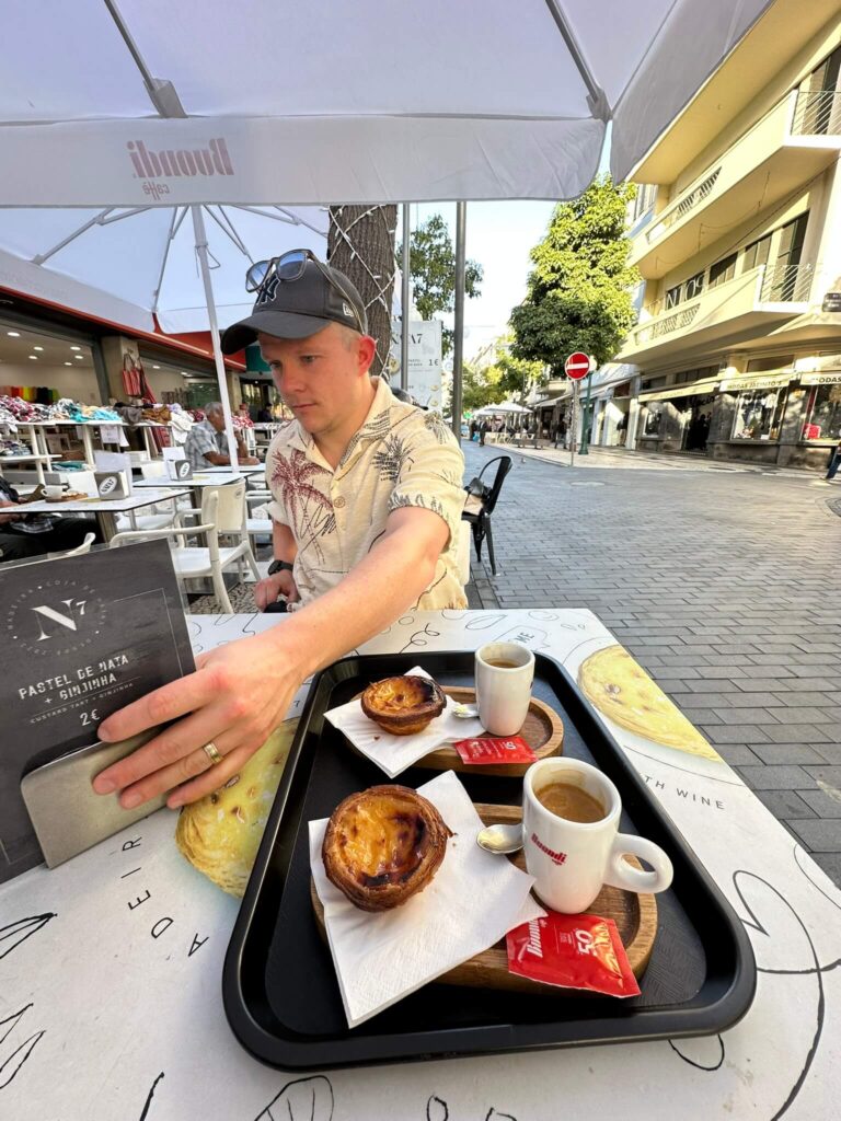 Man sitting in cafe having pastel de nata and esspresso
